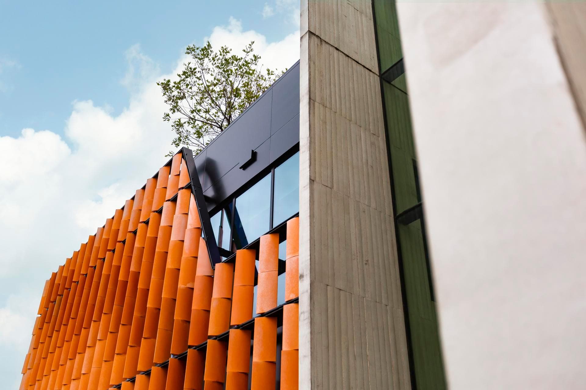 Stairwell façade lined with ALPOLIC™ NC/A1 aluminium panels in Mandarin Orange