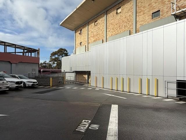 Silver Metallic ALPOLIC™ façade with yellow safety bollards
