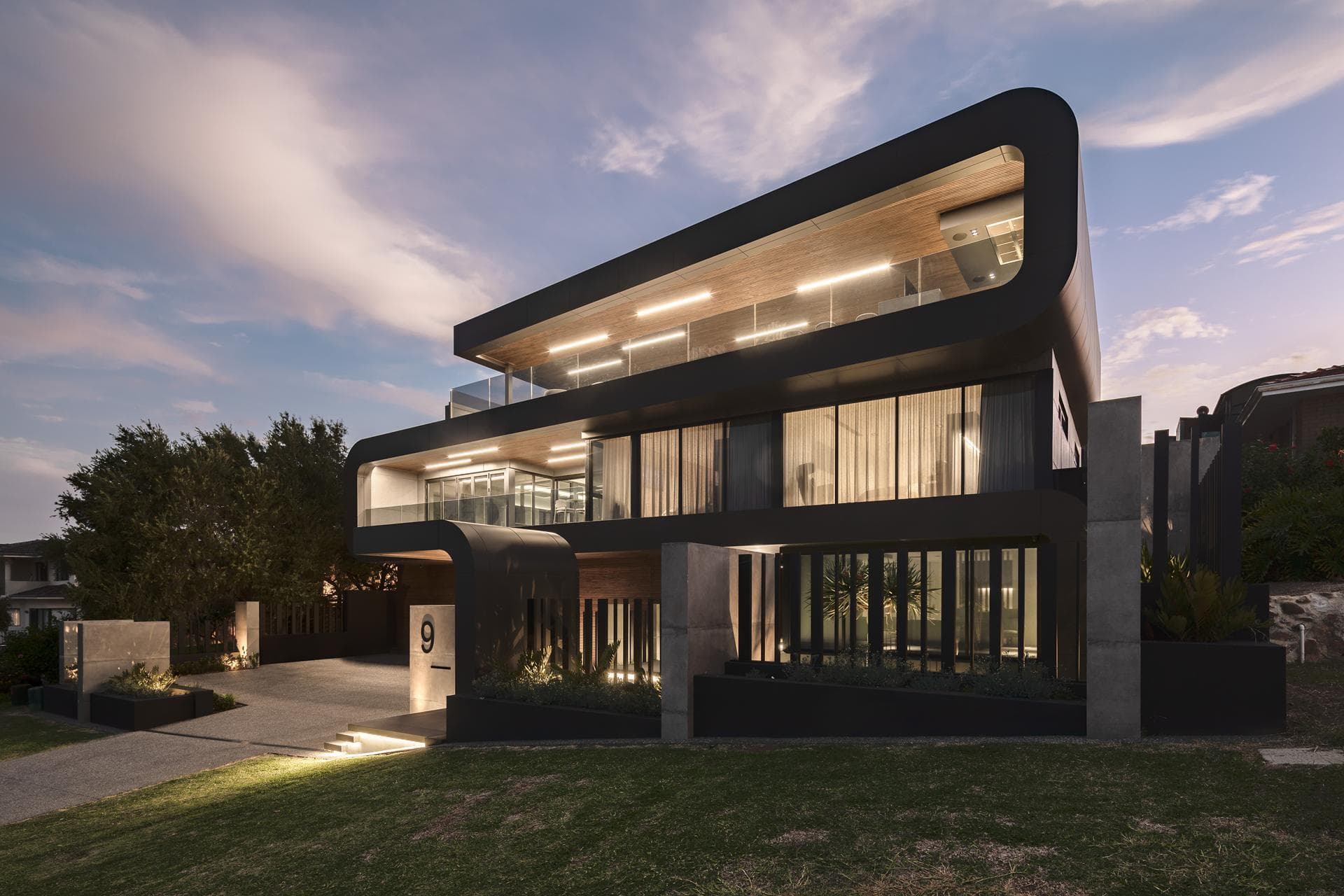 Angled dusk view of 9 Stoke Street highlighting ALPOLIC™/fr Matte Slate Black façade with illuminated interiors